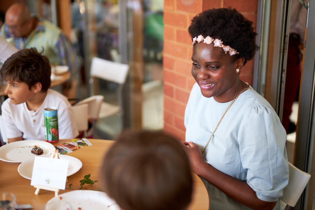A Newbold Church member sharing a meal and conversation with a young boy after a service